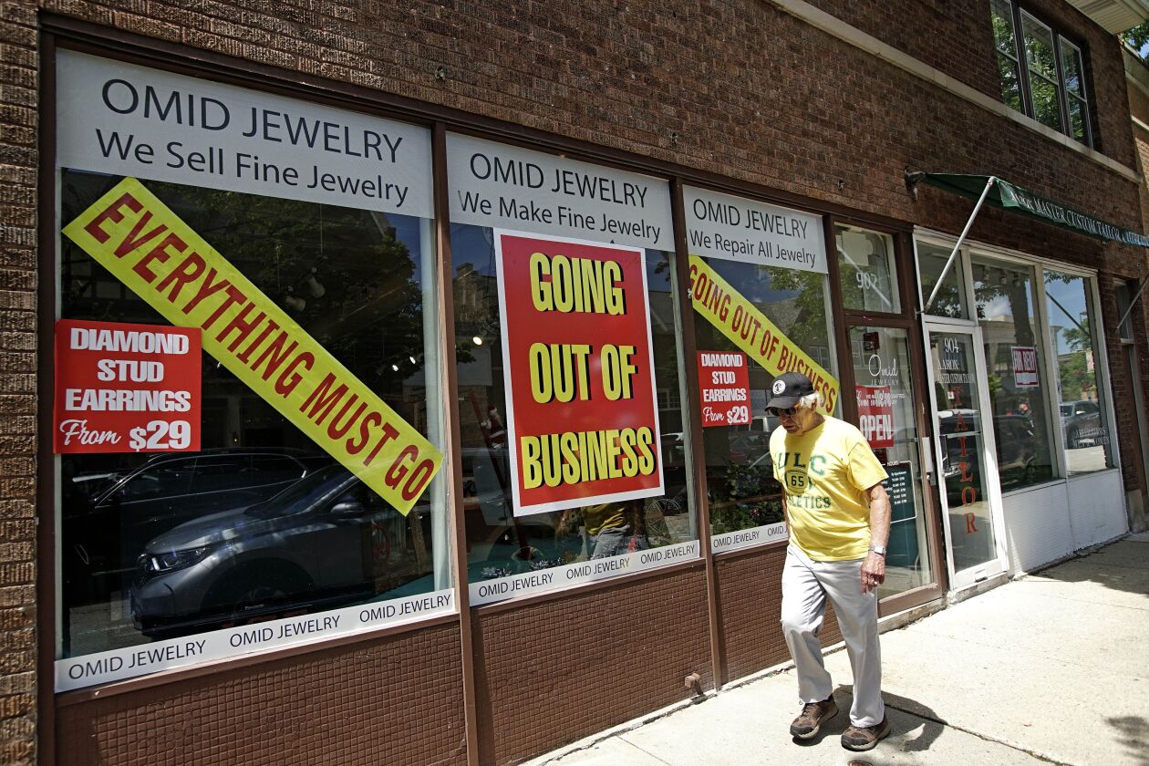 A man walks past a retail store that is going out of business due to the coronavirus pandemic in Winnetka in June.